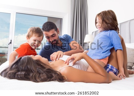 Happy funny kids playing in parents bed