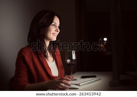 Woman in video call with a glass of wine on desk