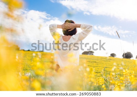 Back view of a woman in yellow field