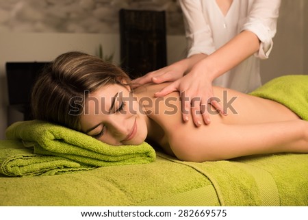 Woman having a back massage in spa beauty center