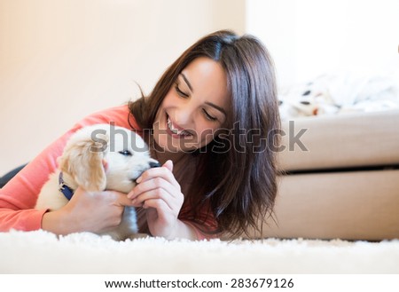 Woman lying on floor with a puppy