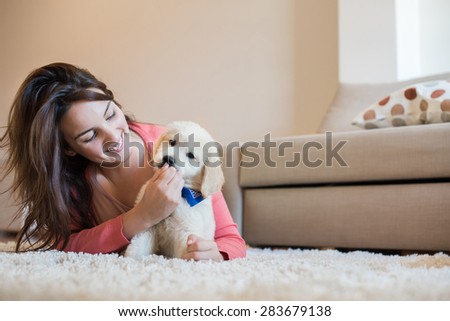 Woman laying on floor with a puppy