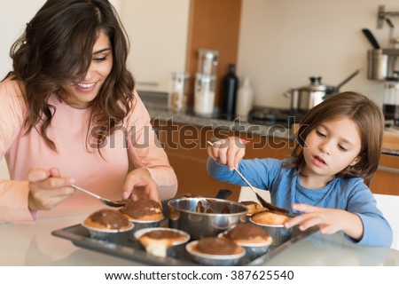 Mother and daughter making cupcakes in kitchen
