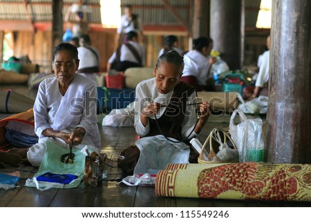 SANGKLABURI-AUG 13: Unidentified old Mon women count chaplets on hands at wat Uttama in Sangklaburi, Thailand on August 13, 2011. Counting chaplets is Mon mediation culture on Buddhist holy day.