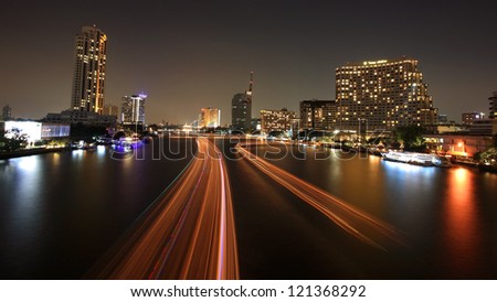 BANGKOK-DEC 05: Cityscape of boat light trails on Chao Phraya River in Bangkok, Thailand on December 05, 2012. Boat can transfer to historic, business, and resident spots around Bangkok by 9 piers.