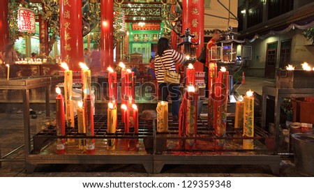 BANGKOK-FEB 09: Unidentified people incense near big candles to pray in Chinese new year day at Kuan Yin shrine on February 09, 2013 in Bangkok, Thailand. Here is located near China town Gateway Arch.