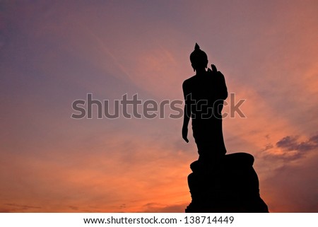 Silhouette of Buddha statue with ray light at twilight in Phutthamonthon, Thailand