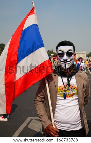 BANGKOK-DEC 9: Unidentified Thai protester wearing  Guy Fawkes mask with Thai flag on December 09, 2013 in Bangkok, Thailand. Millions of Thai people rally from many streets to expel government today.
