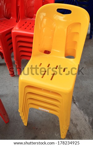 Stack of yellow and red plastic chairs