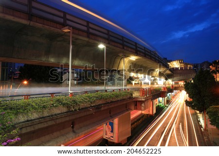 BANGKOK, THAILAND - JULY 07, 2012: Light trails on elevated rail at Victory monument station with twilight sky. Elevated rails cover business, resident, and tourist areas by 32 stations