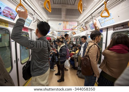TOKYO, JAPAN - NOVEMBER 07, 2015: Unidentified people in subway train of Tokyo Metro pass. The transit system carries almost 8 million passengers a day.