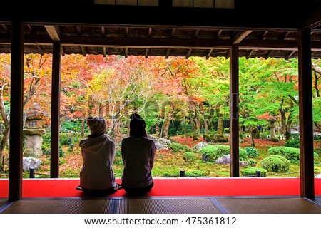 Two Japanese girls enjoy Autumn colorful Japanese garden at Enkoji temple in Kyoto, Japan. Here is the Rinzai Zen Sect and very famous during fall colors in Autumn.