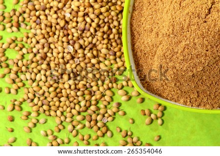 Coriander seeds and Powdered coriander in green container on green background