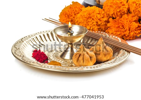 Beautifully Decorated Pooja Thali for festival celebration to worship, huldi or turmeric powder and kumkum, flowers, scented sticks in brass plate, hindu puja thali