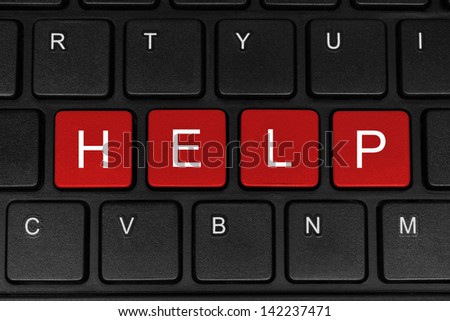 The word help made of four red buttons of a black keyboard close-up
