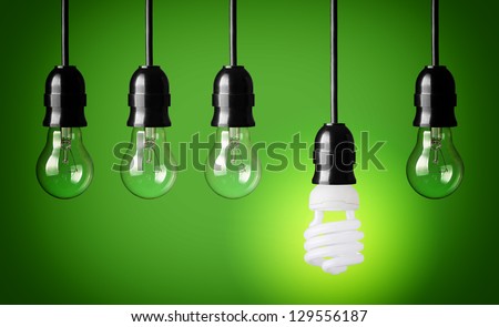 Idea concept with light bulbs and energy save bulb. Green background.