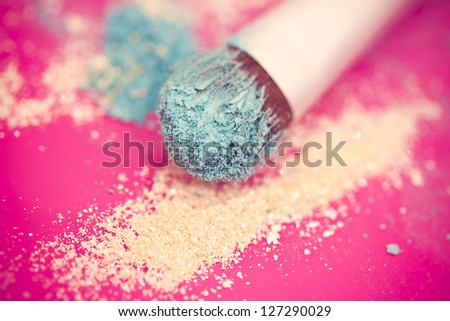 close-up shot of make-up brush with blue eyeshadow powder