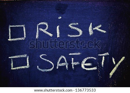 chalk writings on blackboard, choice between risk and safety