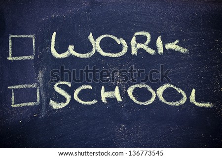 chalk writings on blackboard, choice between work and school