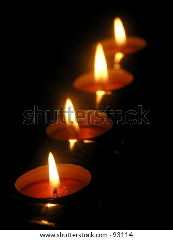 Small candles on a row. Focus on the one in the foreground.