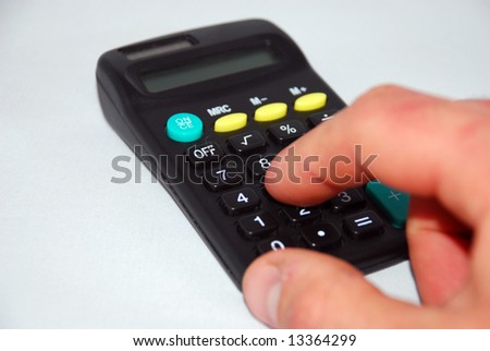 Small personal calculator detail with a finger pressing the equals sign