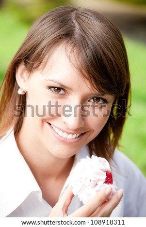Portrait of young happy smiling woman with cake outdoors