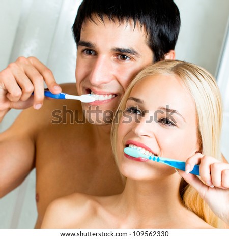 Cheerful young couple cleaning teeth together