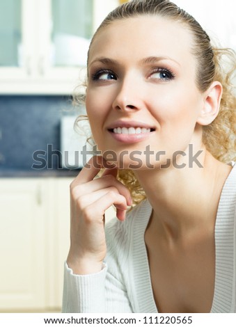 Portrait of young smiling beautiful blond woman thinking, indoors