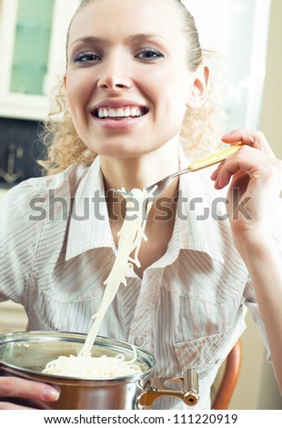 Cheerful young woman eating spaghetti