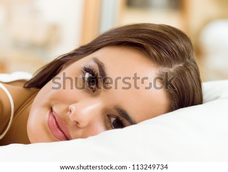 Young beautiful happy smiling woman waking up on bed
