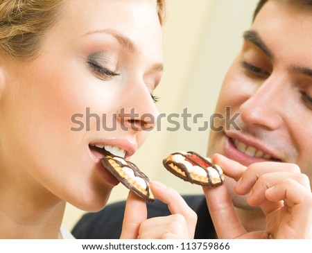 Cheerful couple eating cookies