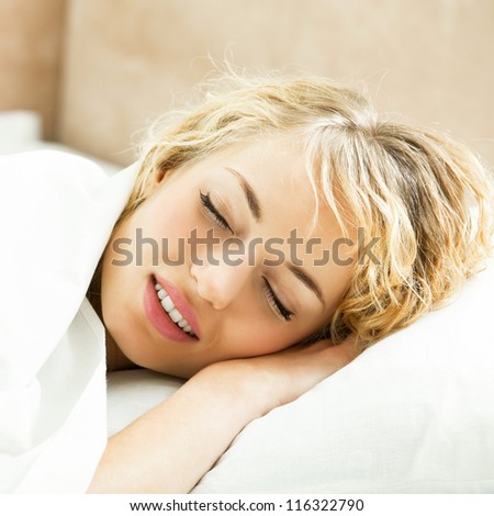 Young beautiful blond woman sleeping on bed