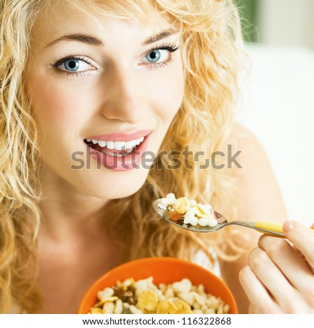 Cheerful blond woman eating cereal muslin
