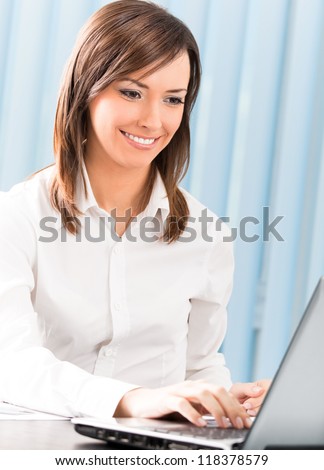 Portrait of successful happy smiling business woman working with laptop at office