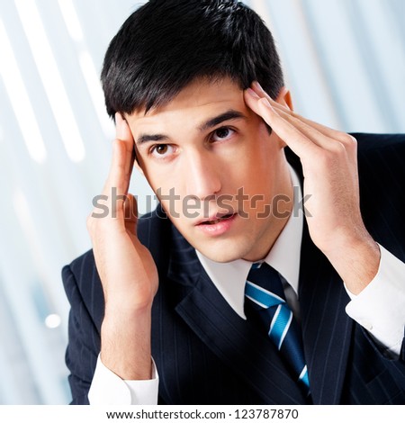 Thinking, tired or ill with headache businessman at office