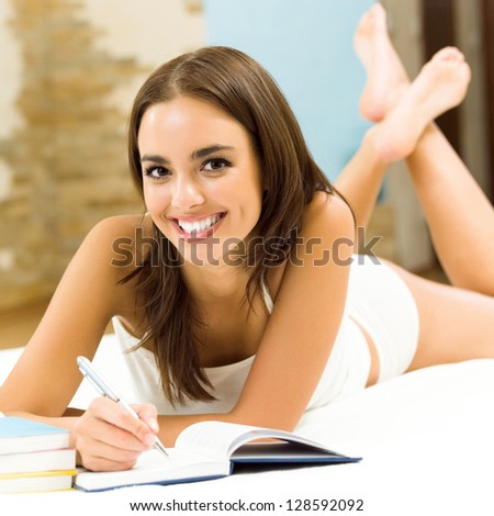 Young beautiful woman studying with notebook or organiser, indoors