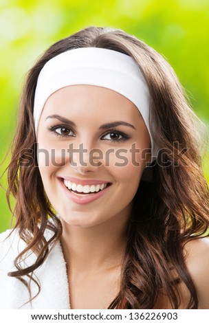 Portrait of happy smiling young beautiful woman in fitness wear, outdoors