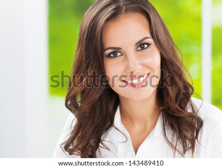 Portrait of young happy smiling cheerful business woman at office