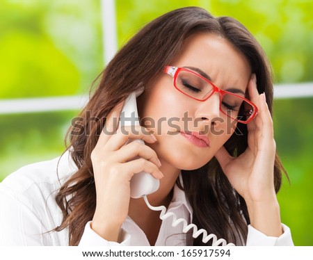 Thinking, tired or ill with headache business woman with phone at office