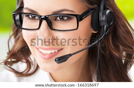 Portrait of happy smiling cheerful beautiful young support phone operator in headset