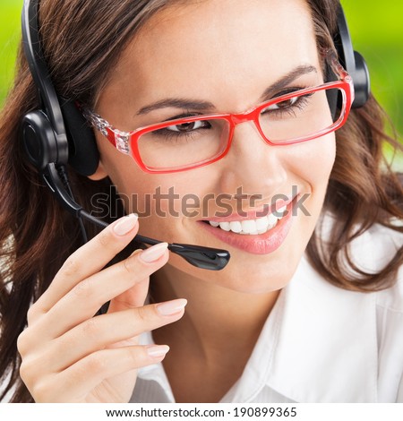 Portrait of happy smiling cheerful beautiful young support phone operator in headset, at office