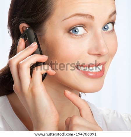 Young happy smiling business woman with cell phone, at office