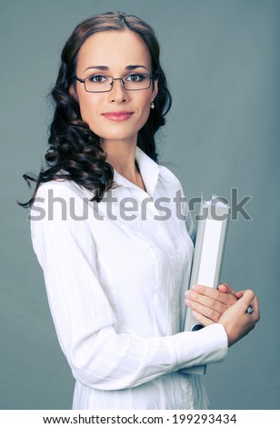 Portrait of happy smiling business woman with gray folder, over gray background