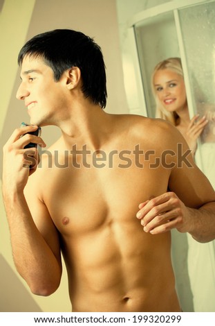 Shaving man and young woman at bathroom