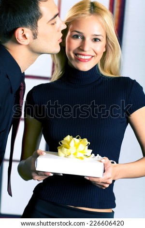 Young happy attractive happy smiling business people or couple with gift