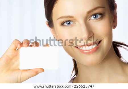 Portrait of smiling business woman giving blank business card, at office