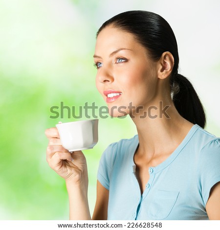 Young happy smiling beautiful woman drinking coffee, outdoor