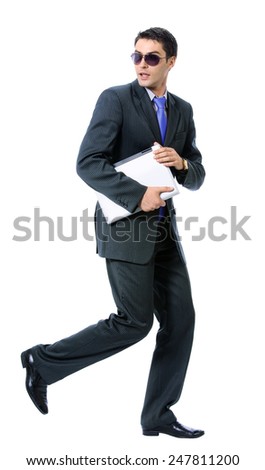 Full body of young businessman or hacker in sun glasses with laptop running, isolated against white background