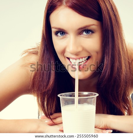 Portrait of cheerful young woman drinking milk