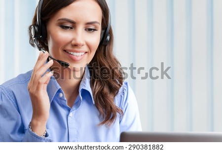 Portrait of happy smiling cheerful beautiful young female support phone operator in headset, at office, with blank copyspace area for slogan or text. Customer assistance service concept.